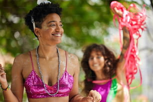 a woman in a pink bikini top standing next to another woman in a purple bikini