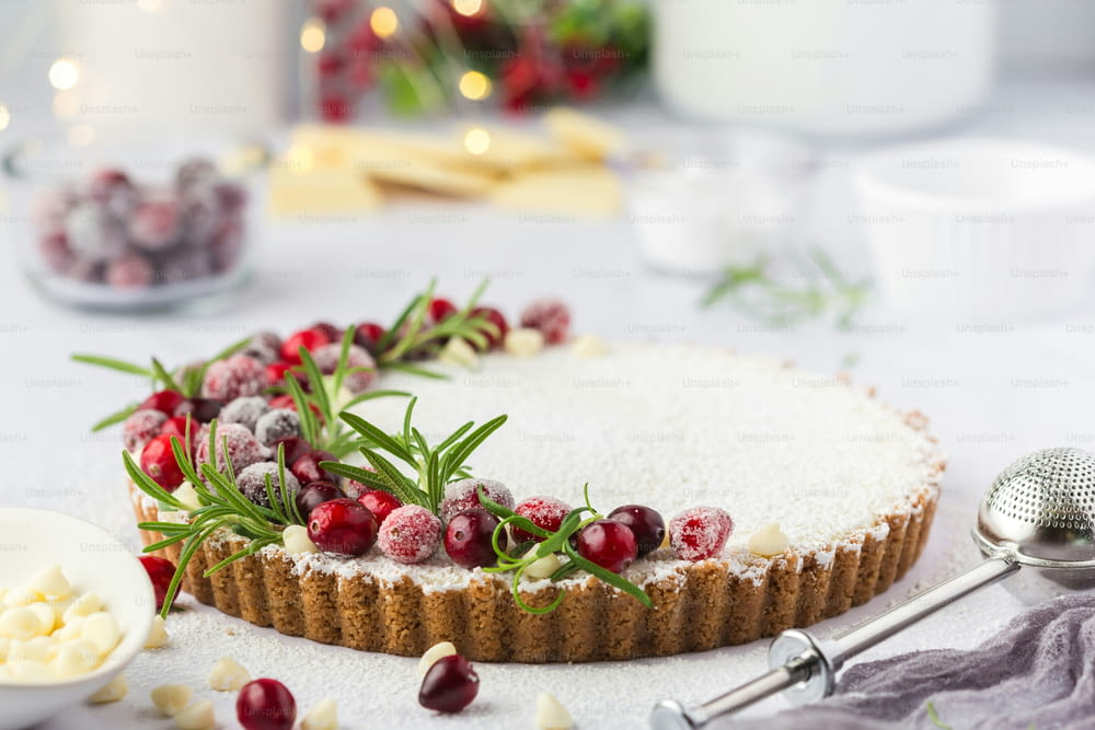 a table topped with a cake covered in cranberries