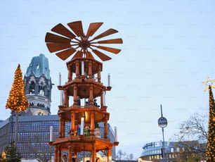 una grande torre dell'orologio di legno seduta in mezzo a una strada