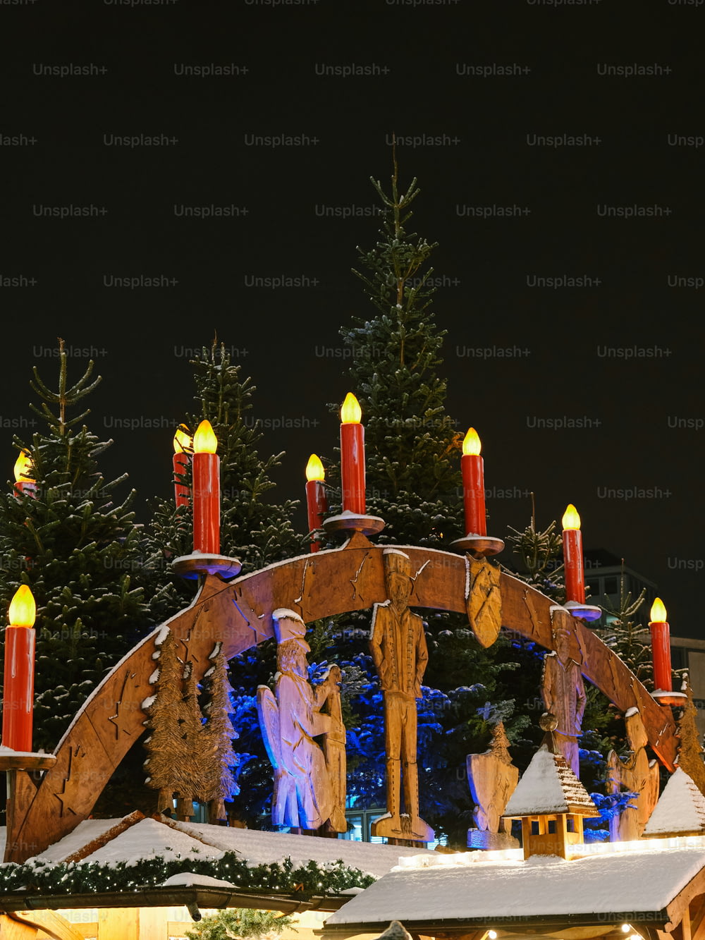 a christmas display with lit candles and a man and woman