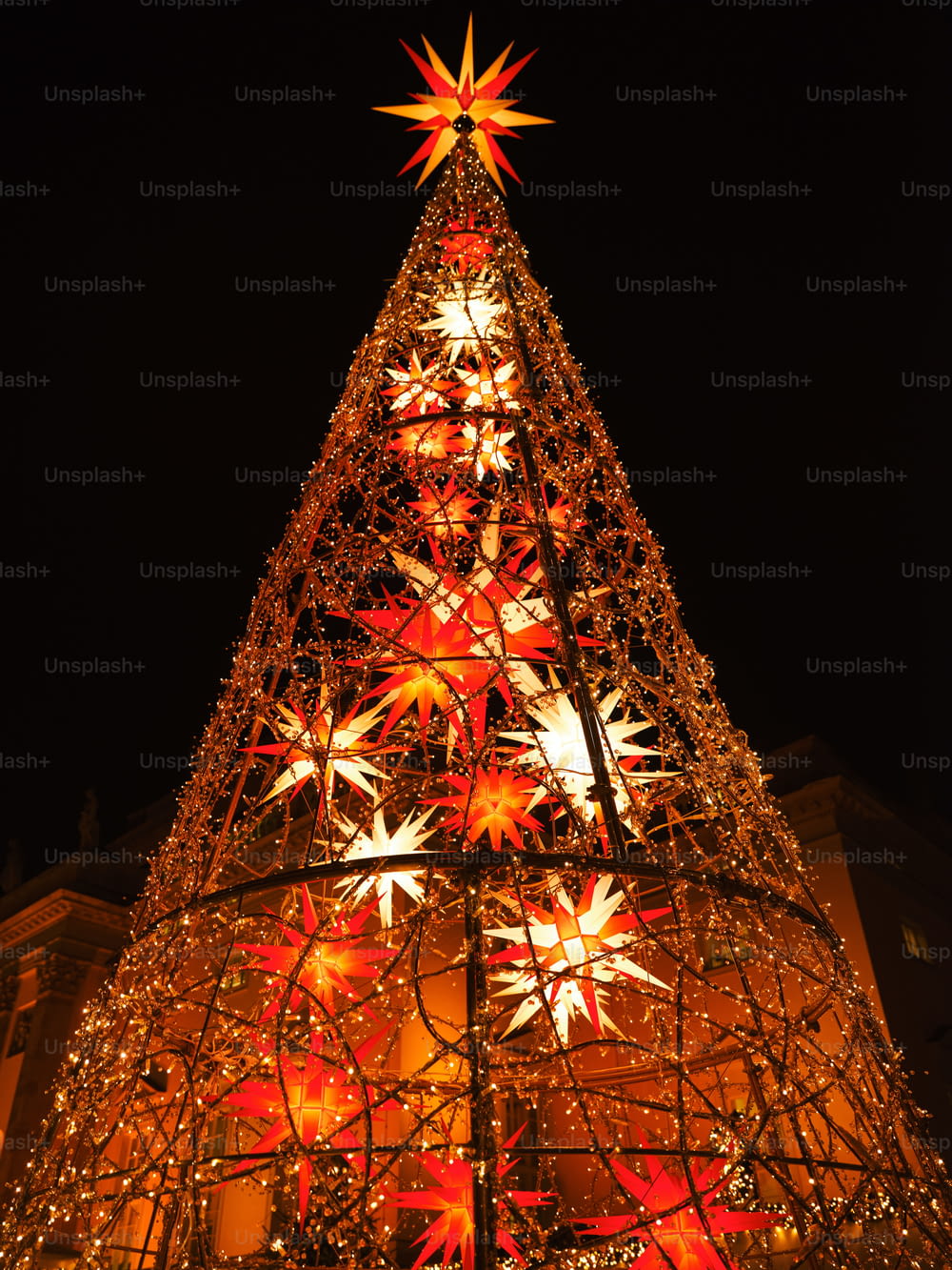 a lighted christmas tree in front of a building