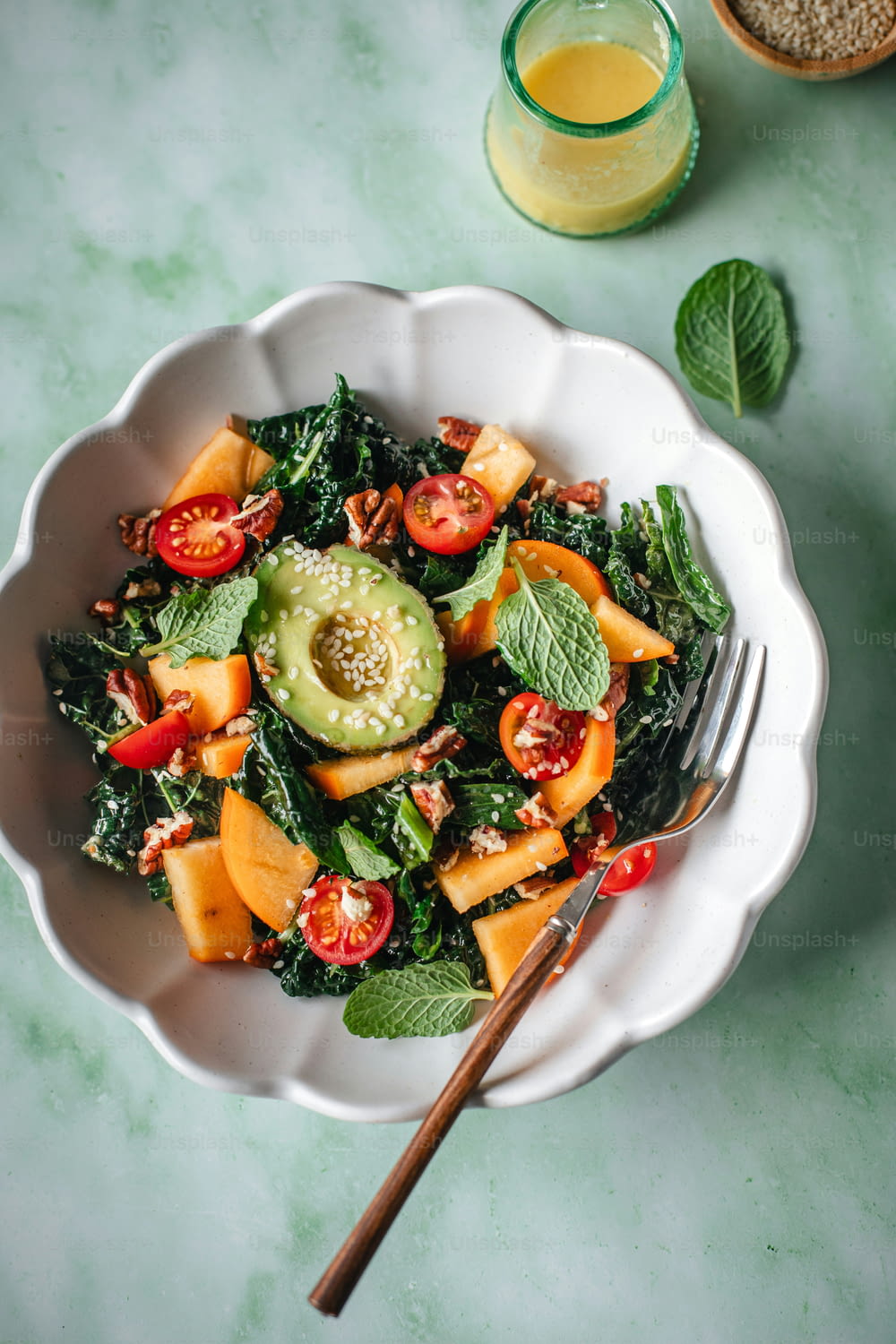 a salad with avocado, tomatoes, and spinach