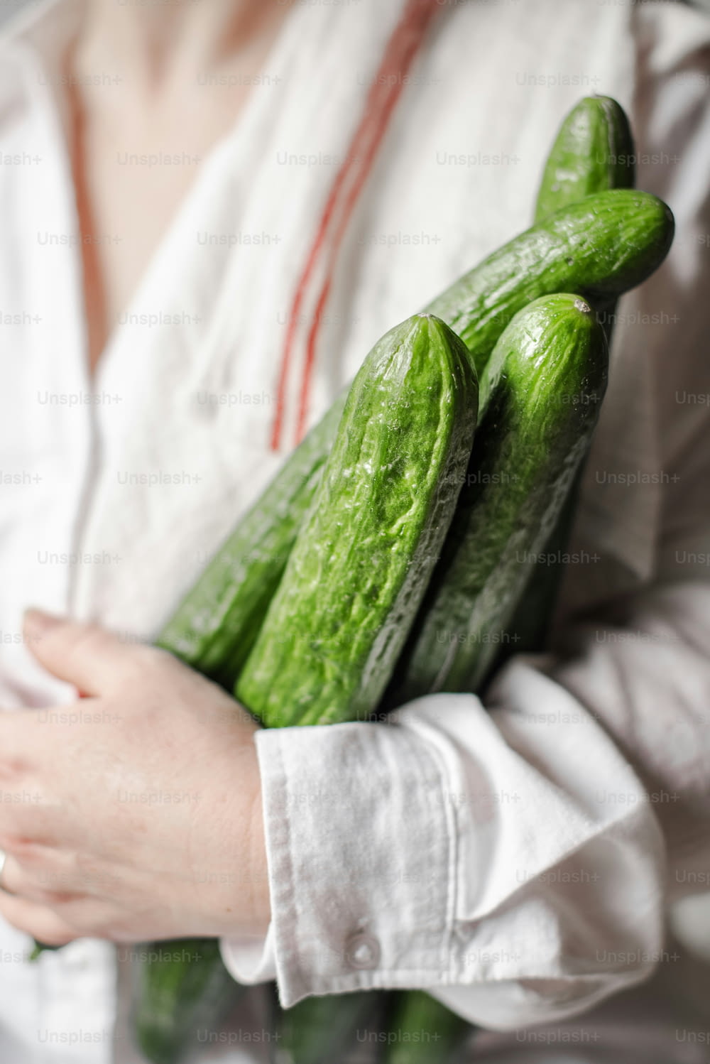 a close up of a person holding a bunch of pickles