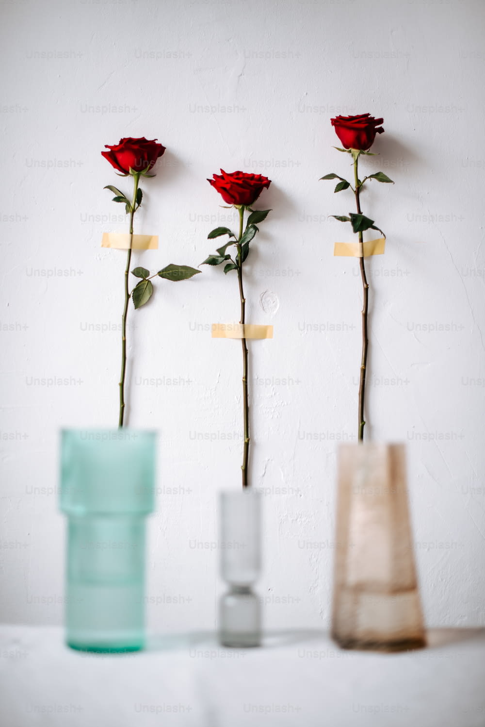three vases with roses in them on a table