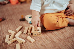 a baby playing with wooden blocks on the floor