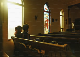um casal de pessoas que estão sentadas em uma igreja