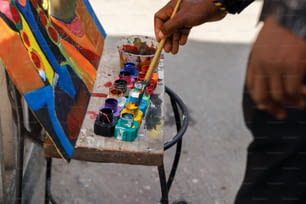 a man is holding a paintbrush and painting on a canvas