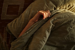 une personne enveloppée dans une couverture sur un lit