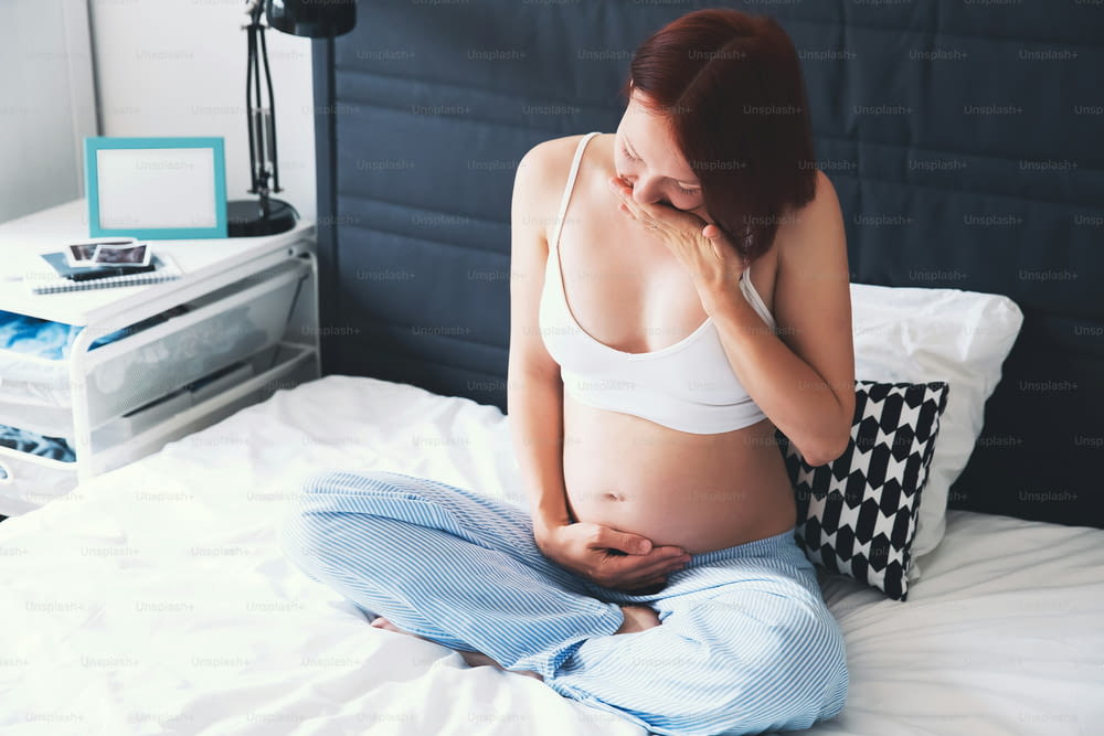 Probleme oder Symptome eines schlechten Gesundheitszustands während der Schwangerschaft. Schwangere Frau, die unter Übelkeit in häuslichen Innenräumen leidet. Schwangerschaft, Elternschaft, Vorbereitungs- und Erwartungskonzept.