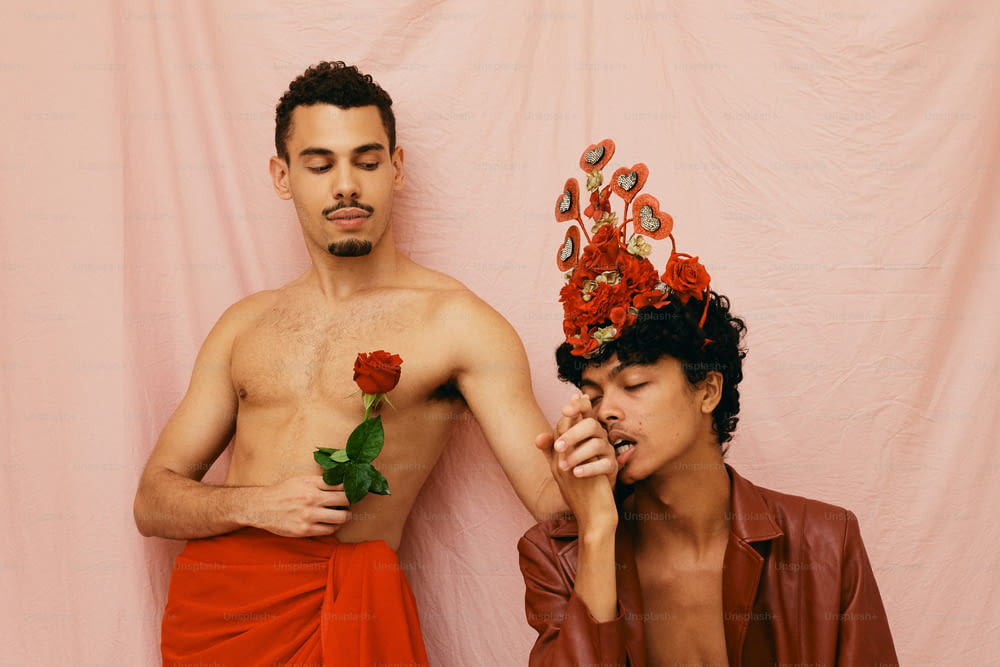 a man with a flower crown on his head next to a man with a rose