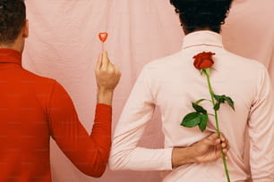 um homem segurando uma rosa na frente de uma mulher