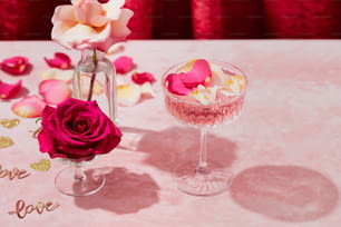 um copo de vinho e um vaso de flores sobre uma mesa