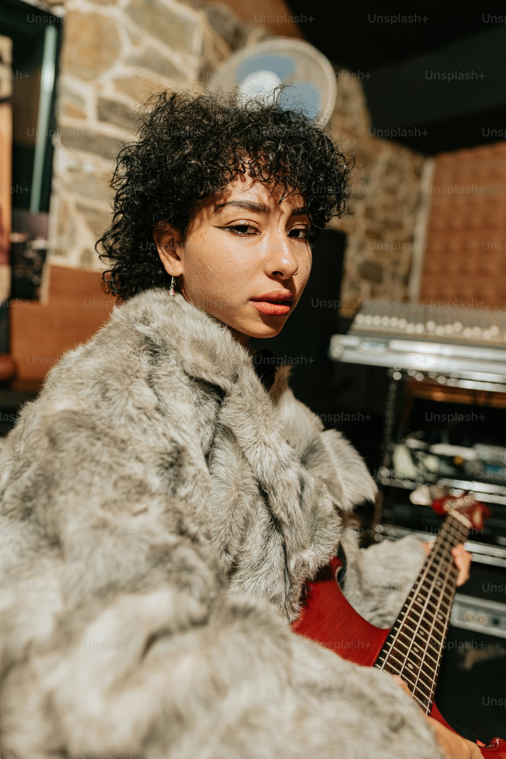 a woman in a fur coat holding a guitar
