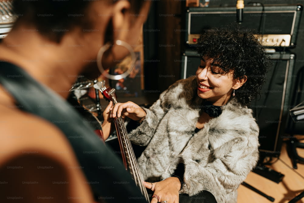 a woman in a fur coat playing a bass