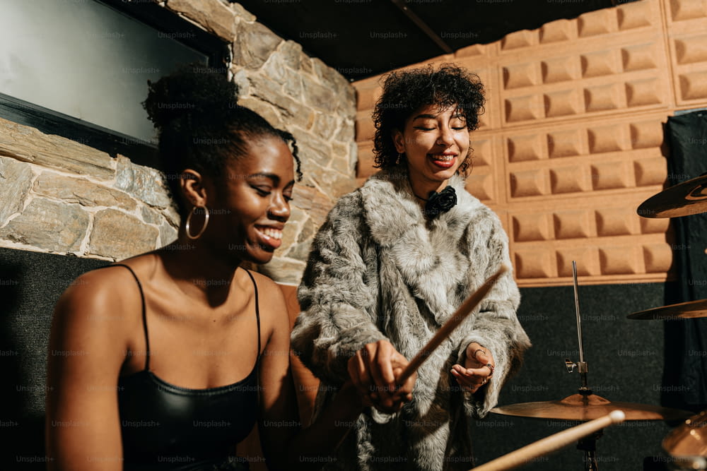 two women playing drums in a recording studio