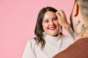 Uma mulher está sorrindo enquanto coloca o cabelo de um homem