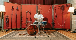 a man sitting in front of a drum set