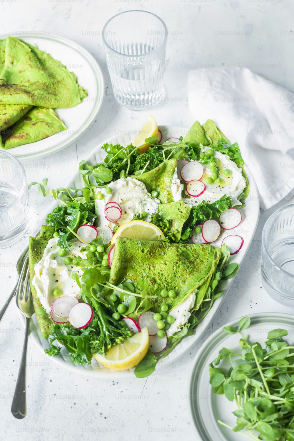 une assiette blanche garnie d’une salade recouverte de légumes