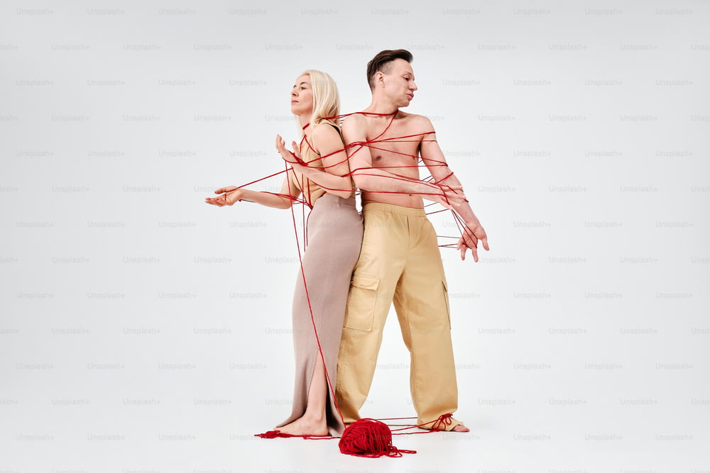 a man and a woman tied up to strings