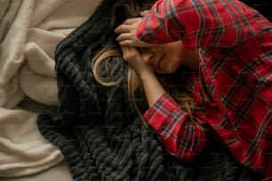 una donna sdraiata sopra una coperta sopra un letto