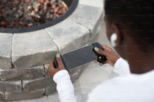 a person holding a cell phone in front of a fire pit