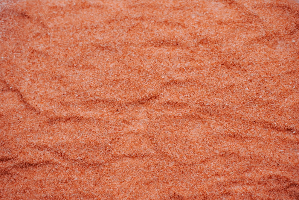 un primo piano di una superficie di sabbia rossa