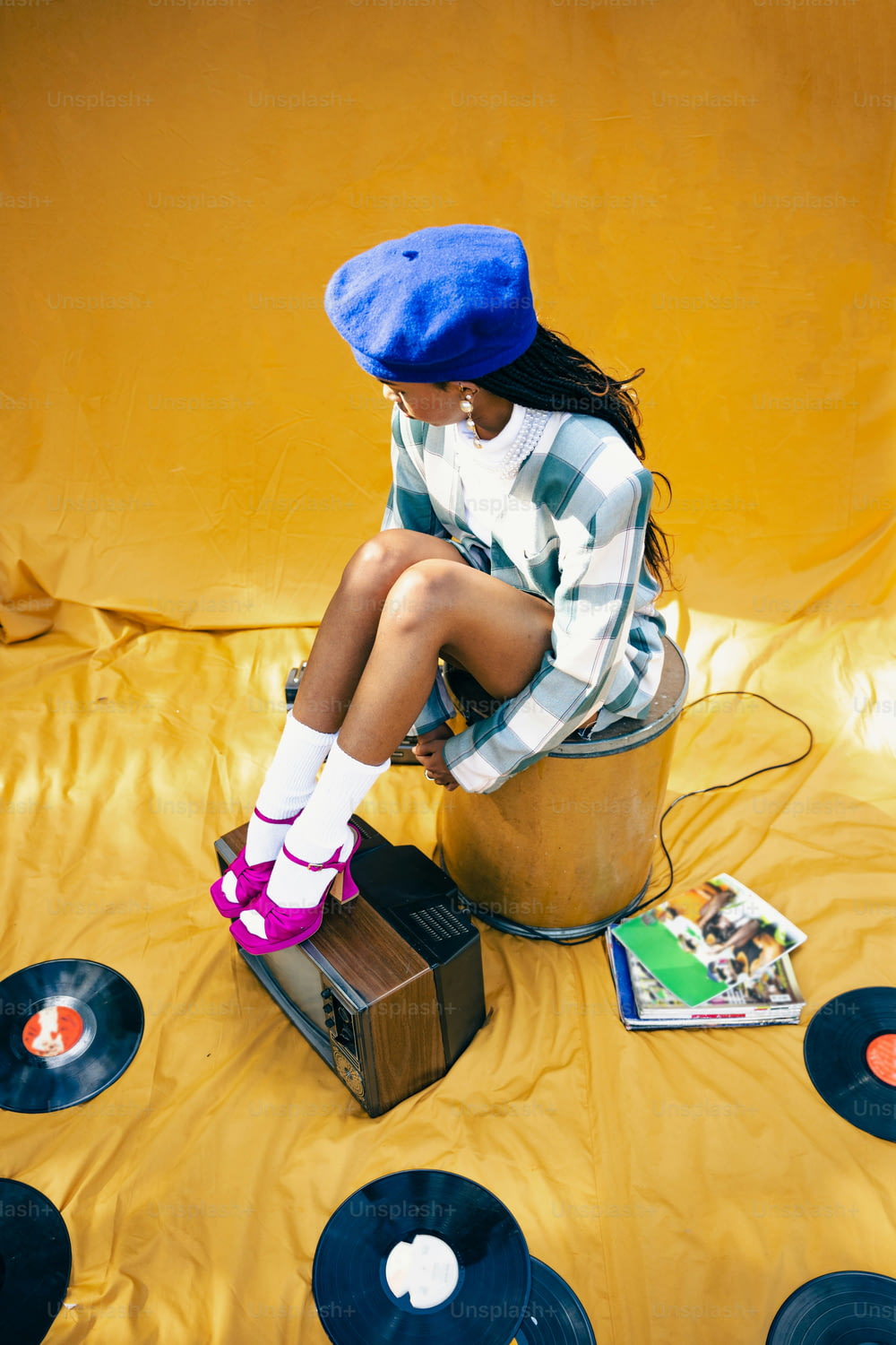Une femme assise sur un seau rempli de disques vinyles