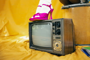 Uma pequena TV com um sapato em cima