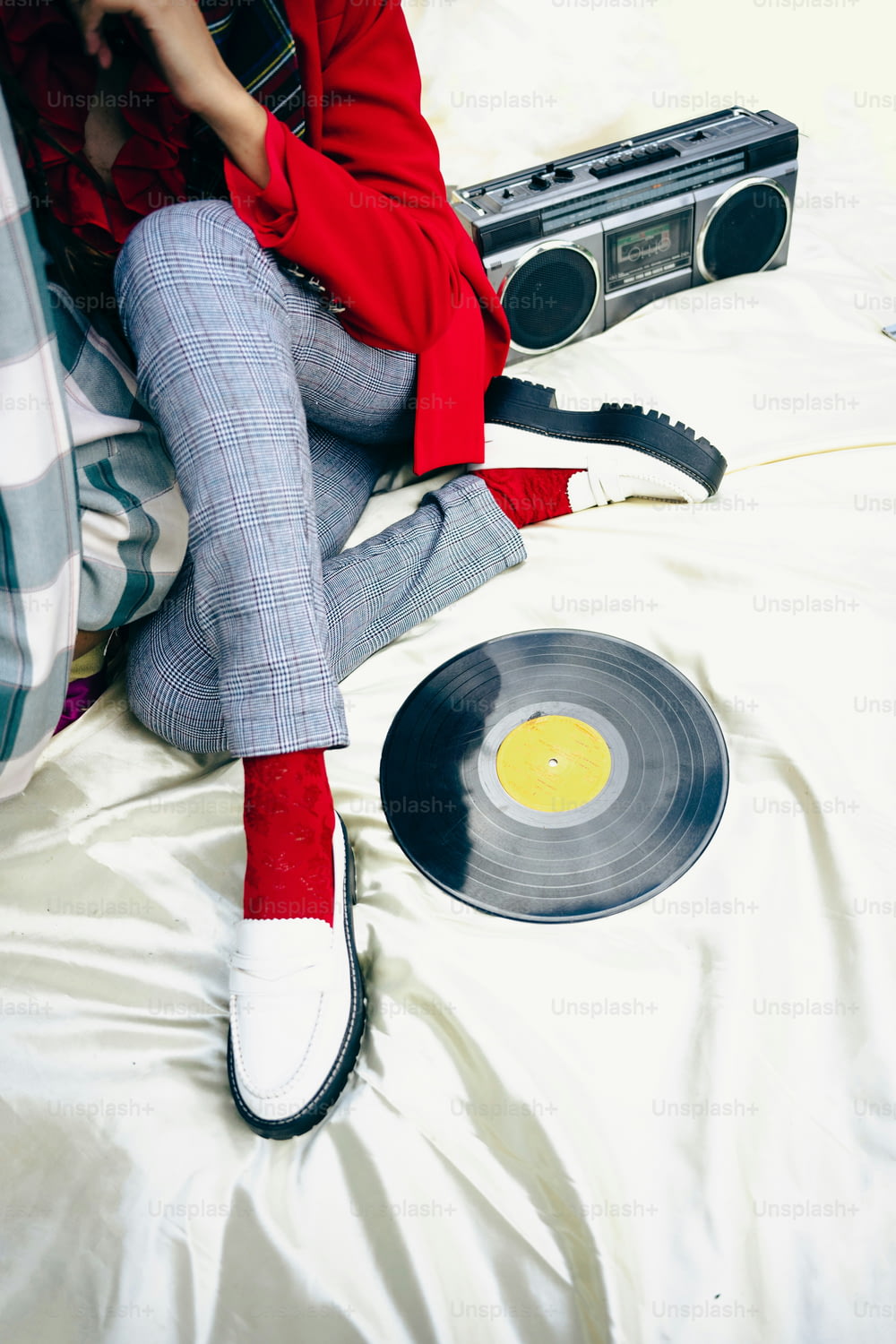 a woman sitting on a bed next to a record player