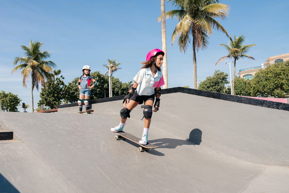 una giovane ragazza che cavalca uno skateboard giù per una rampa