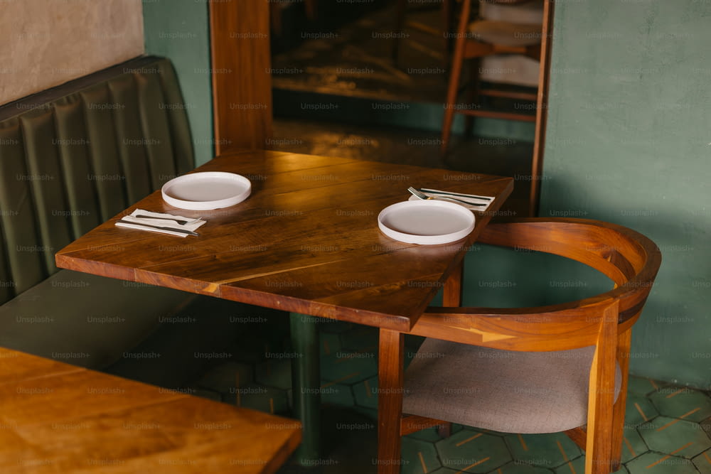 une table en bois avec deux assiettes blanches dessus