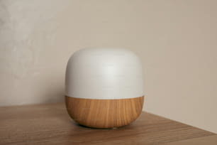 un objeto blanco y de madera sobre una mesa de madera