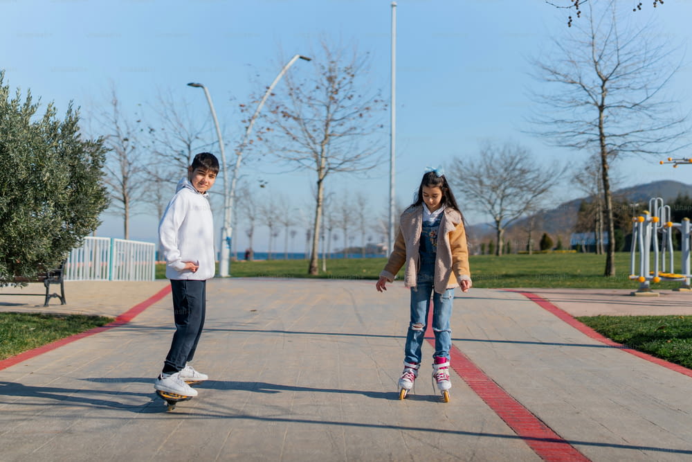 un couple d’enfants faisant de la planche à roulettes sur un trottoir