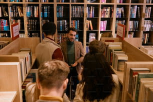 un groupe de personnes debout dans une bibliothèque