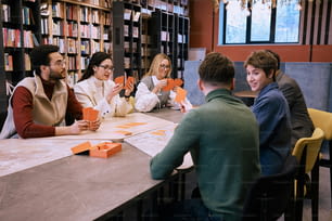 un groupe de personnes assises autour d’une table dans une bibliothèque