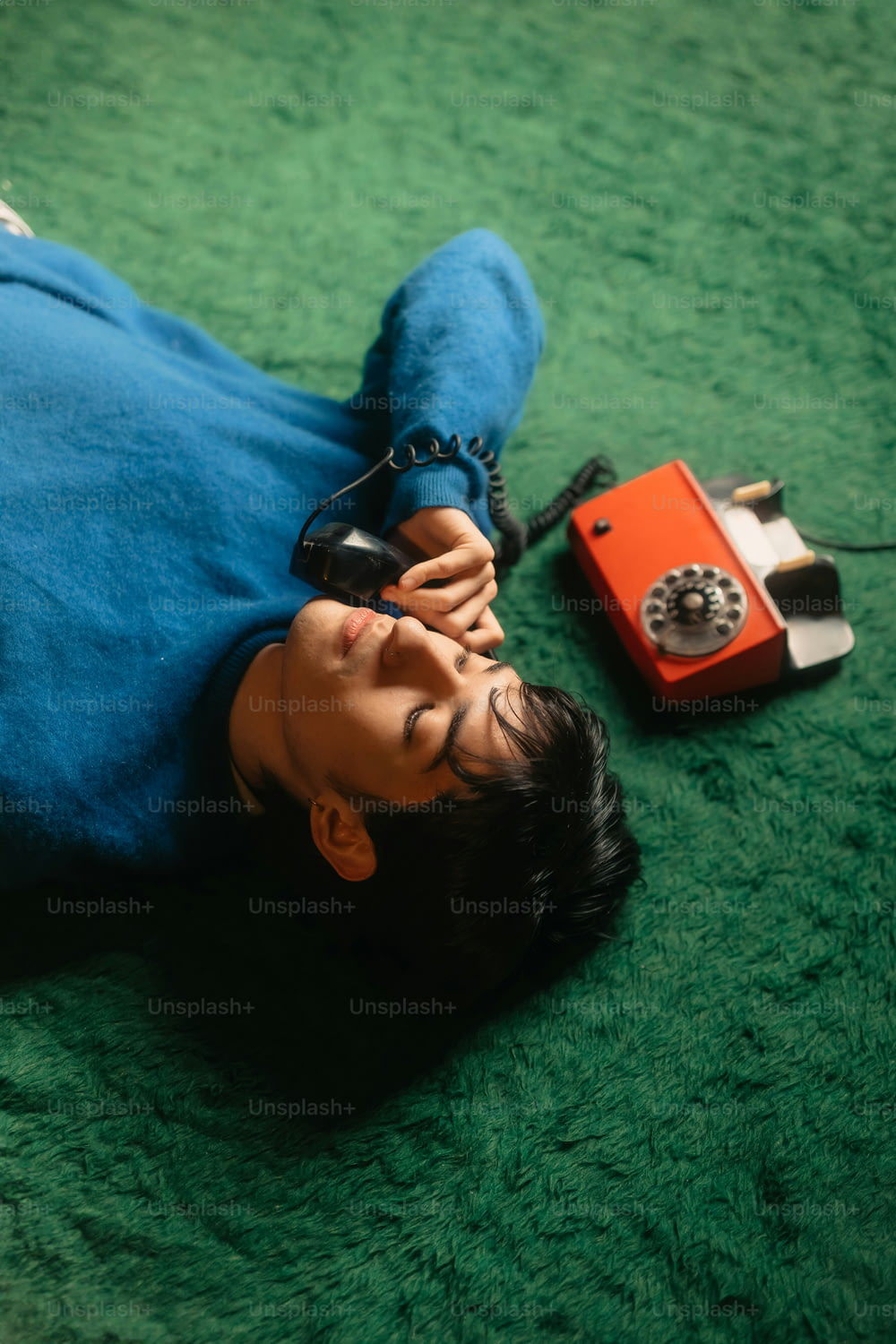 a person laying on the ground with a cell phone