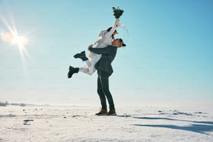 a man holding a woman on his back in the snow
