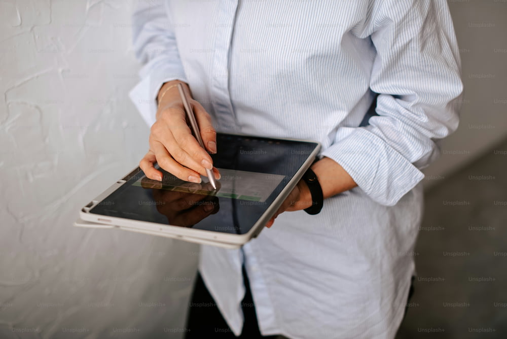 a woman is holding a tablet with a cigarette in her hand