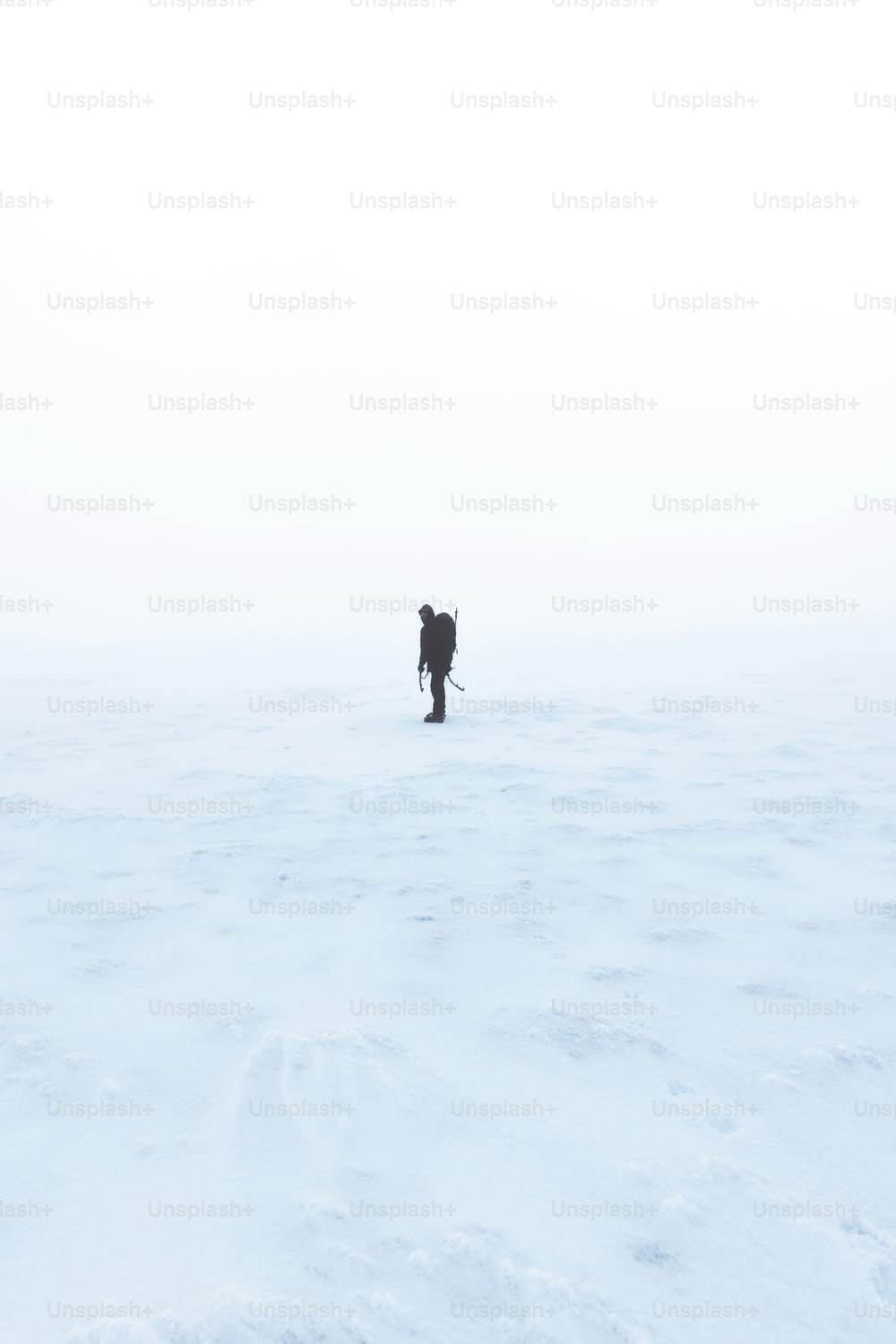 una persona caminando a través de un campo cubierto de nieve