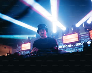 Un hombre en una cabina de DJ con los auriculares puestos