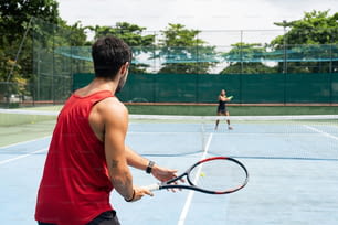 Un hombre sosteniendo una raqueta de tenis en una cancha de tenis