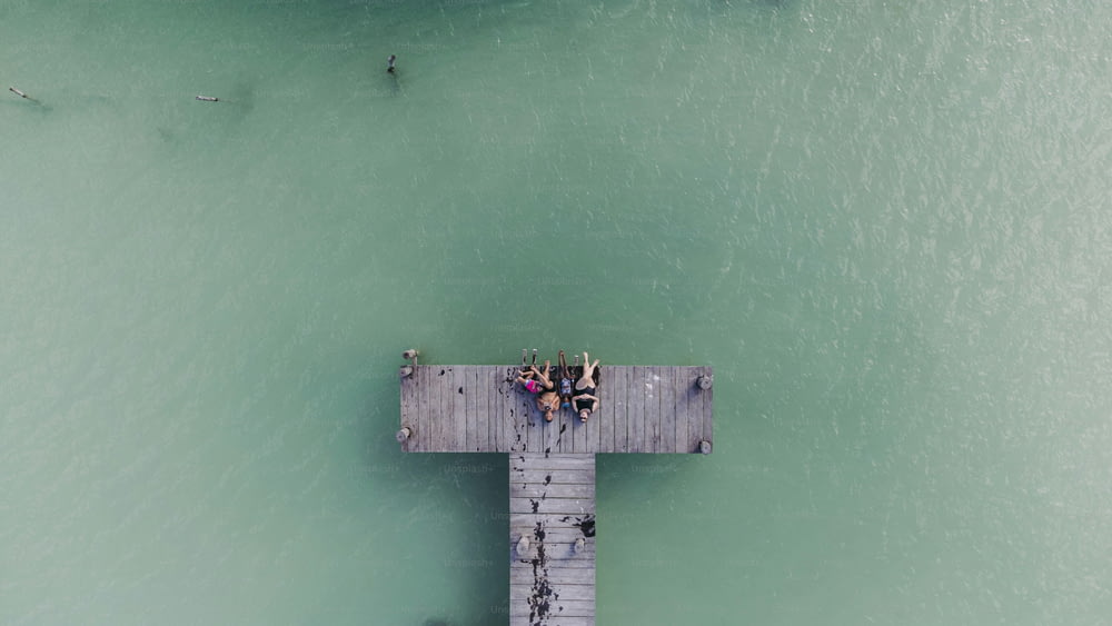 a group of people standing on a pier over the ocean