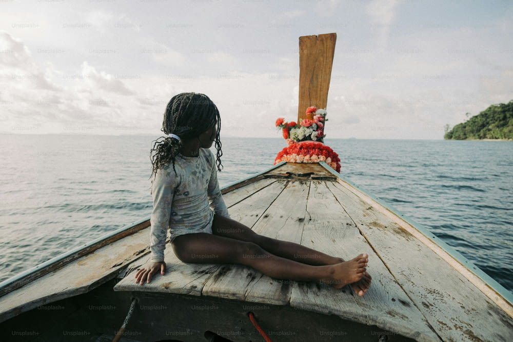 une fille assise sur un bateau dans l’eau