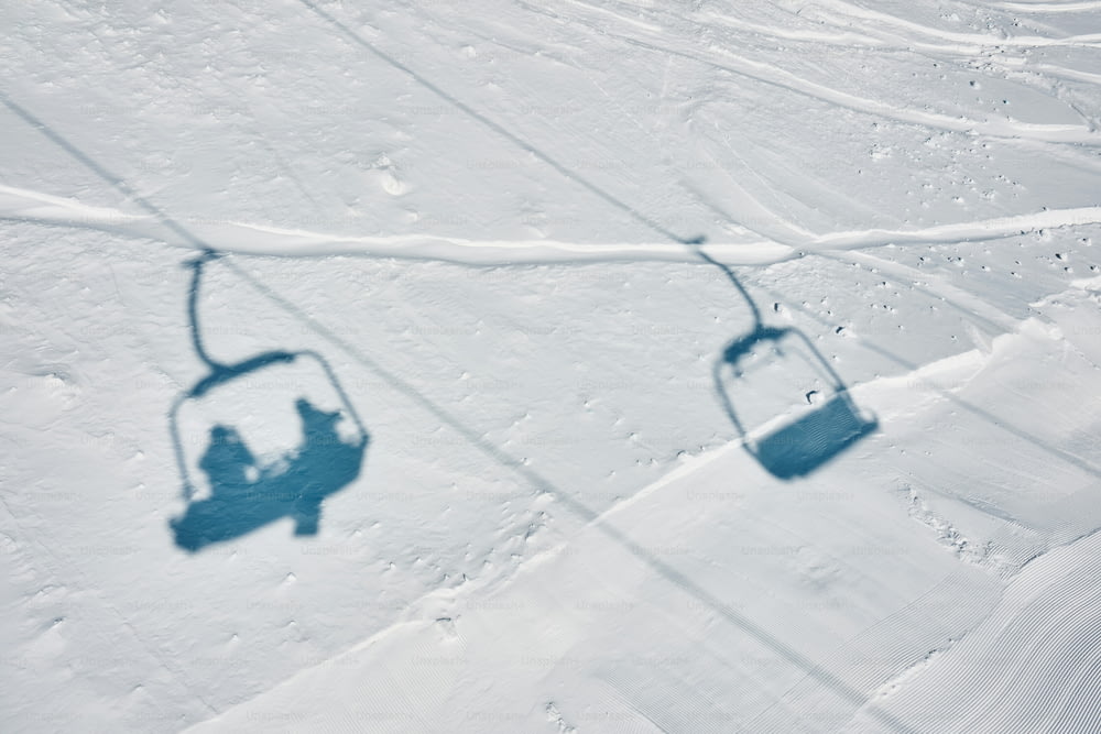 a ski lift with two people on it in the snow