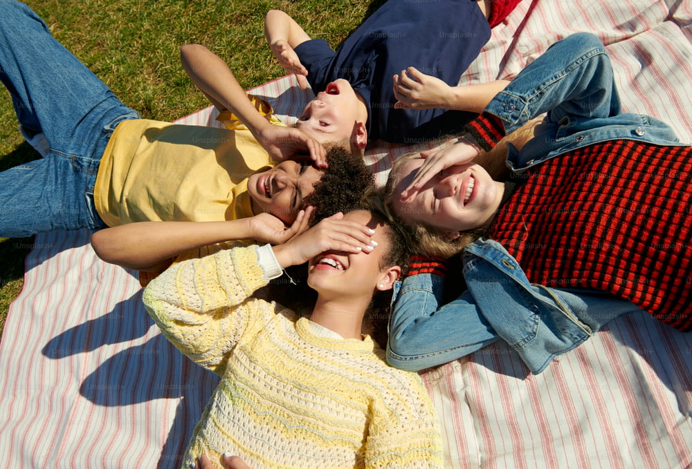 a group of people laying on top of a blanket