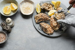 a plate of oysters on a table with lemons
