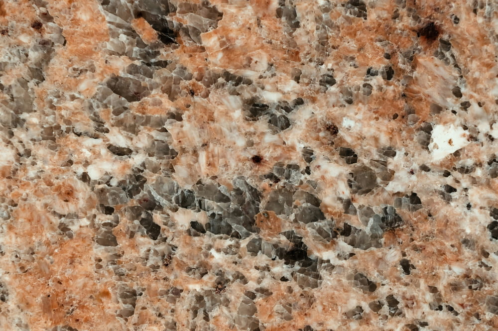 a close up of a marble surface with orange and black colors