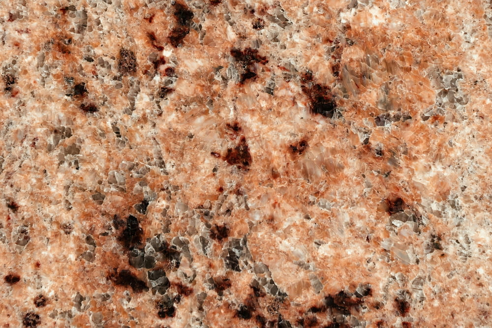 a close up of a marble surface with red and black speckles