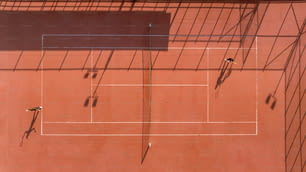 an overhead view of a tennis court with shadows
