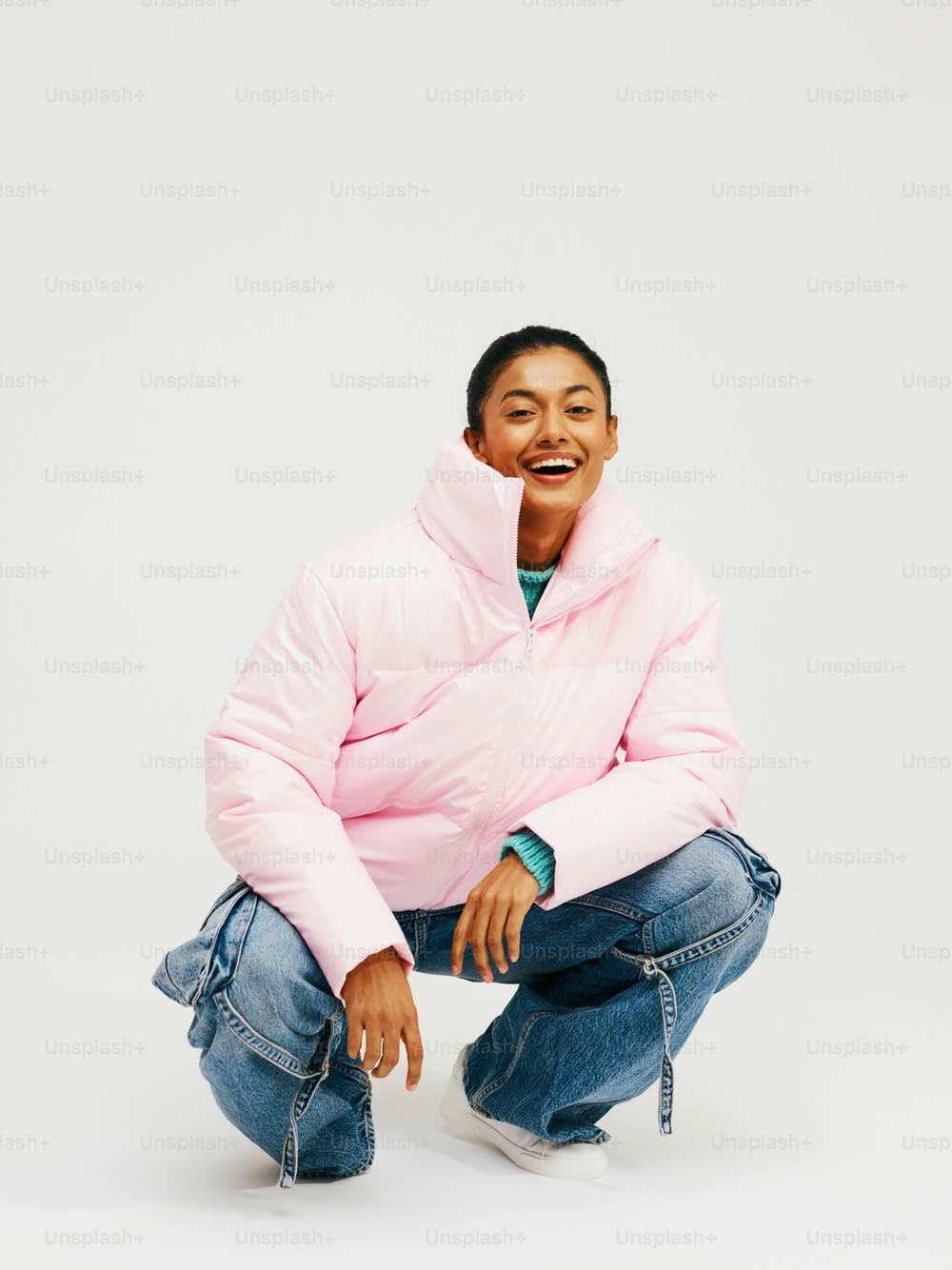 a man in a pink jacket squatting down